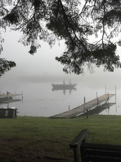 Fisherman just off the dock on Cut Foot Sioux Lake as the morning fog lifts