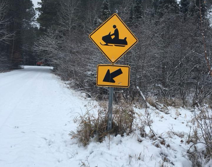 snowmobile crossing sign along a snowy road